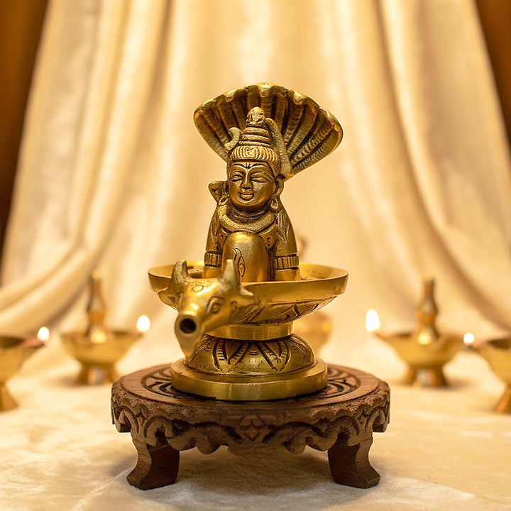 4.7 Inch Brass Shivalingam and Sheshnag Figurine showcasing Lord Shiva’s sacred lingam with the protective hood of Sheshnag — a divine symbol of power and cosmic energy. No.1 Brass Idol Store www.satvikstore.in 