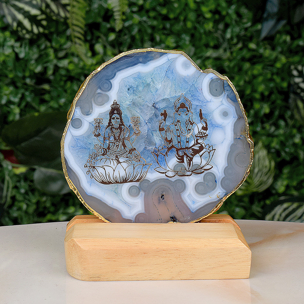 Agate stone stand featuring intricately carved Laxmi and Ganesha idols, mounted on a polished natural agate base for spiritual and decorative use. India’s Largest Pooja Accessories Brand – www.satvikstore.in